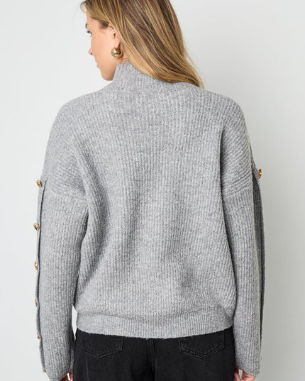 Trui met knopen op de mouwen