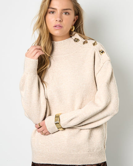 Trui met knopen op de schouder