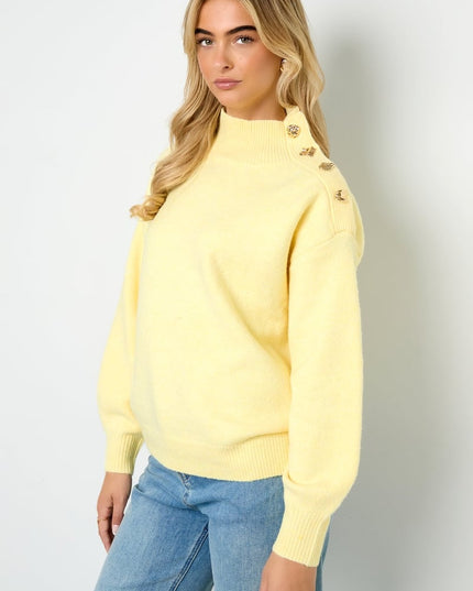 Trui met knopen op de schouder