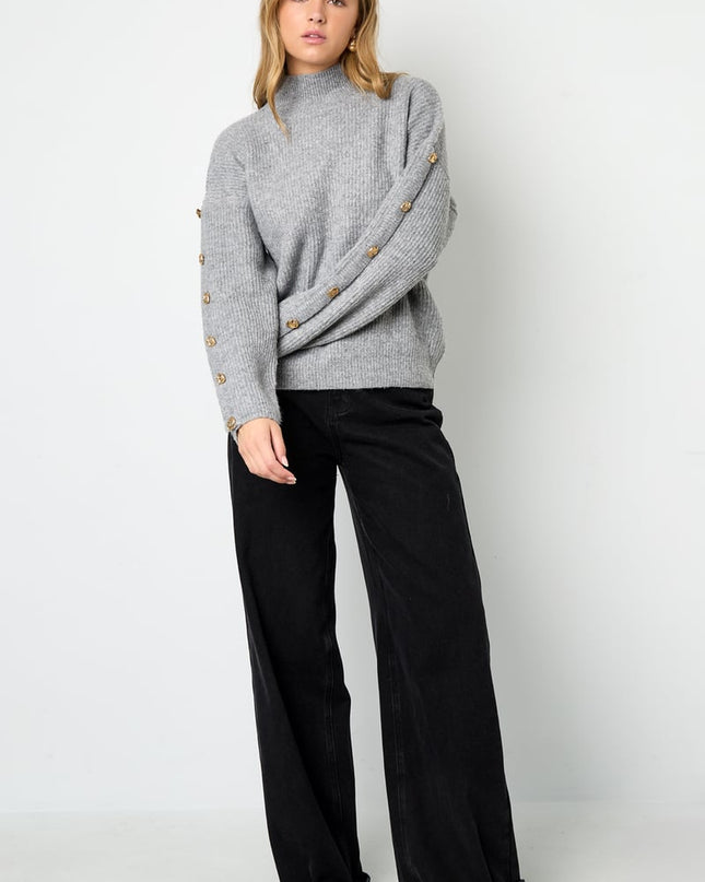 Trui met knopen op de mouwen